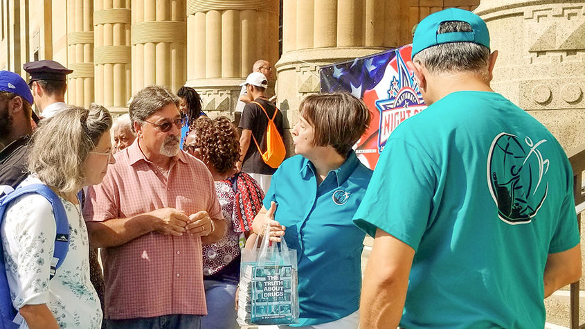 Drugsvrije Wereld voorziet in materialen bij het stadhuis van Buffalo, tijdens de lancering van de National Night Out-activiteiten van die stad.