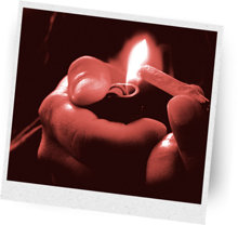 Hands lighting a cannabis joint.